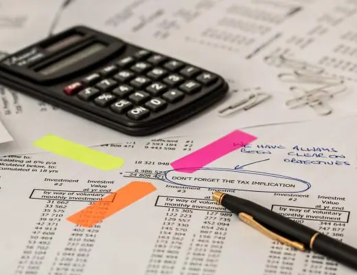 gestionnaire de paie analysant des documents financiers avec calculatrice et surligneurs colorés