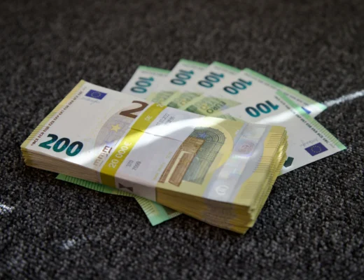 liasse de billets de 100 et 200 euros sur un tapis gris