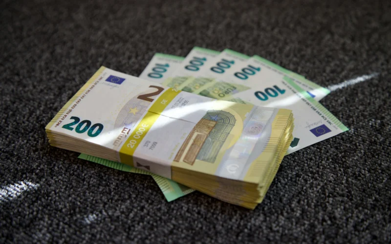 liasse de billets de 100 et 200 euros sur un tapis gris