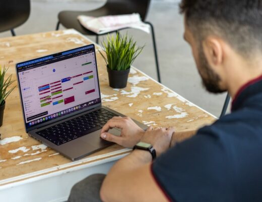 a man sitting at a table using a laptop computer