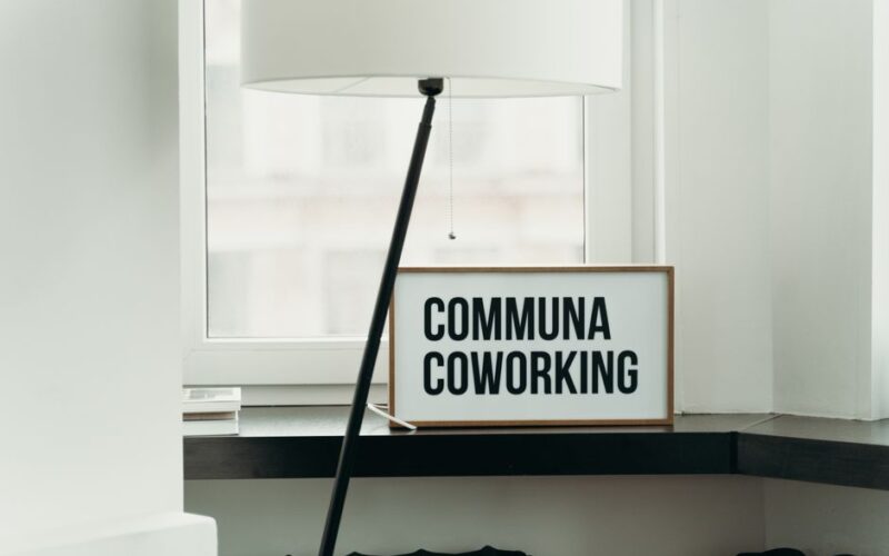 Simple and elegant coworking space decor with soft lamp lighting and window view.