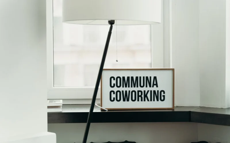 Simple and elegant coworking space decor with soft lamp lighting and window view.
