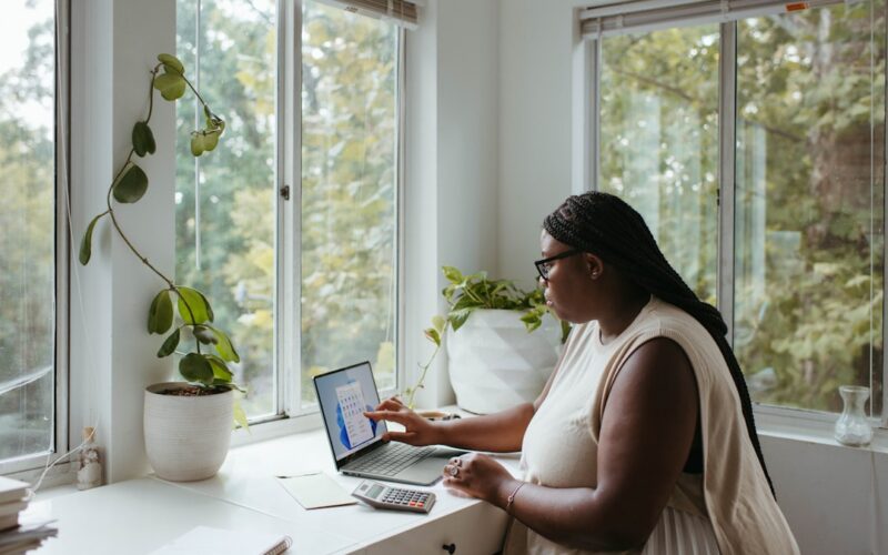 a woman sitting at a table with a laptop