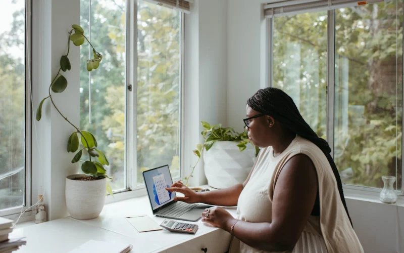 a woman sitting at a table with a laptop