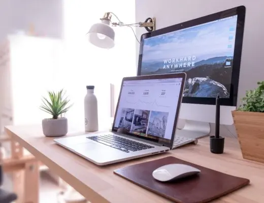 MacBook Pro on table beside white iMac and Magic Mouse