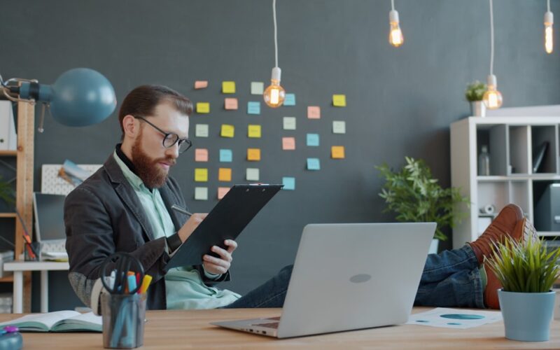 Man working at desk with laptop and notes