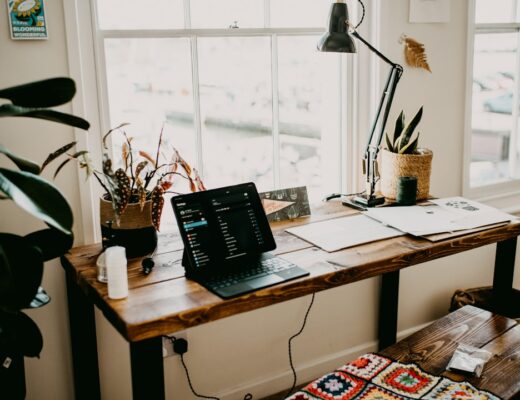 a laptop computer sitting on top of a wooden desk