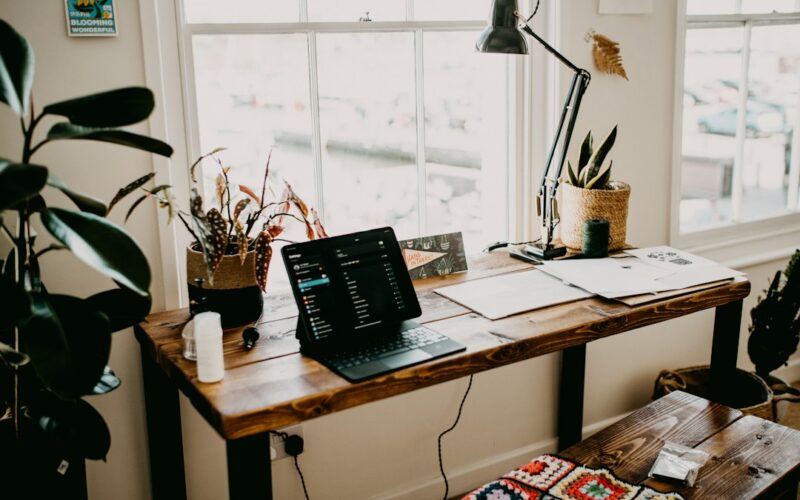 a laptop computer sitting on top of a wooden desk